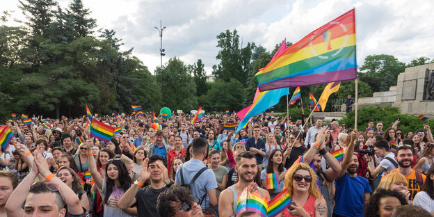 Menschen im Park mit Regenbogenfahnen Menschen im Park mit Regenbogenfahnen