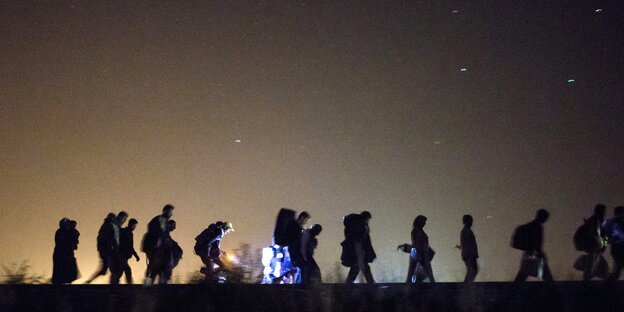 Eine Gruppe von Menschen nachts auf der Flucht Eine Gruppe von Menschen nachts auf der Flucht