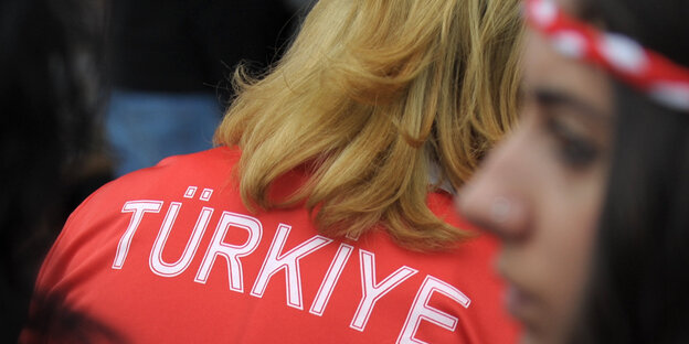 Eine Frau trägt ein rotes T-Shirt, auf dem „Türkiye“ steht Eine Frau trägt ein rotes T-Shirt, auf dem „Türkiye“ steht