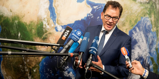 Entwicklungsminister Gerd Müller steht vor zahlreichen Mikrofonen Entwicklungsminister Gerd Müller steht vor zahlreichen Mikrofonen