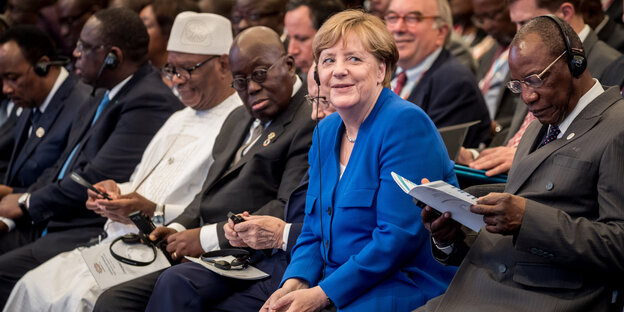 Angela Merkel sitzt zwischen afrikanischen Staatschefs und lächelt Angela Merkel sitzt zwischen afrikanischen Staatschefs und lächelt