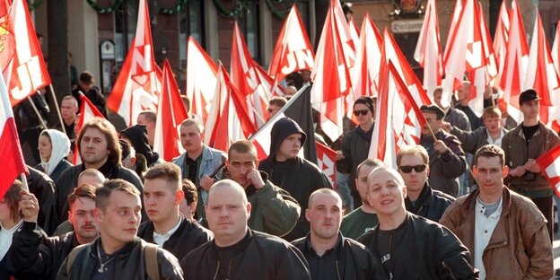 Viele weiße Männer mit rot-weißen Fahnen