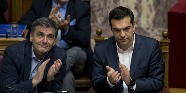 Tsipras und Tsakalotos applaudieren mit finsteren Minen Tsipras und Tsakalotos applaudieren mit finsteren Minen