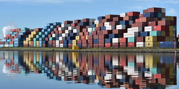 Riesige bunte Container sind an einem Hafen gestapelt Riesige bunte Container sind an einem Hafen gestapelt