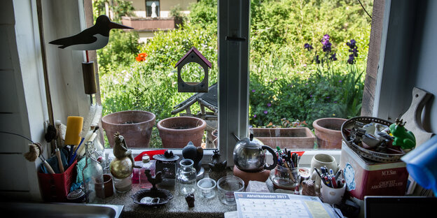 Blick aus einem Küchenfenster auf einen grünen Garten Blick aus einem Küchenfenster auf einen grünen Garten