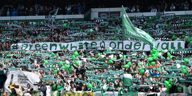 Viele Fußballfans mit Schals, Fahnen und Plakaten stehen in der Bremer Ostkurve Viele Fußballfans mit Schals, Fahnen und Plakaten stehen in der Bremer Ostkurve