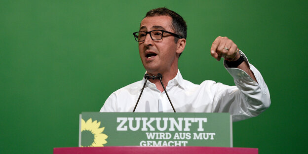 Ein Mann steht an einem Pult Ein Mann steht an einem Pult