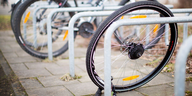 Fahrradständer, an den nur noch ein Reifen angeschlossen ist, der Rest des Fahrrads ist fort Fahrradständer, an den nur noch ein Reifen angeschlossen ist, der Rest des Fahrrads ist fort