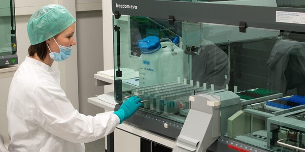 Eine Frau im Labor des LKA Stuttgart arbeitet an einem Pipettierroboter Eine Frau im Labor des LKA Stuttgart arbeitet an einem Pipettierroboter