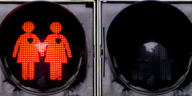 Eine rote Ampel zeigt zwei sich an der Hand haltende Frauen