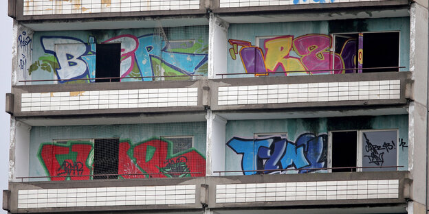 An einer Plattenbauwand zwischen Balkonen sind bunte Grafittis zu sehen An einer Plattenbauwand zwischen Balkonen sind bunte Grafittis zu sehen