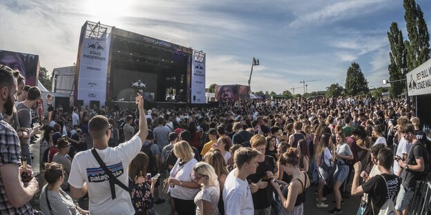 Musikfans stehen vor einer Bühne Musikfans stehen vor einer Bühne