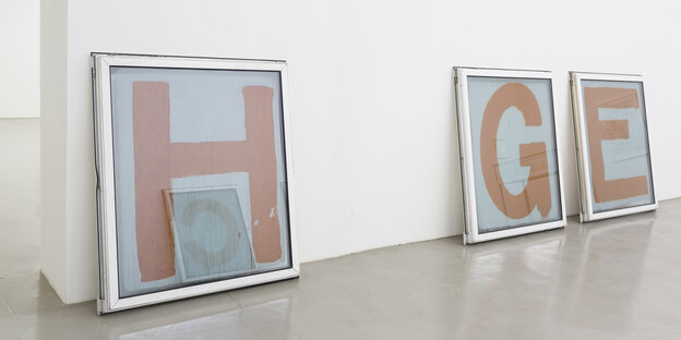 Mit Buschstaben bemalte Fenster stehen in einer Galerie Mit Buschstaben bemalte Fenster stehen in einer Galerie