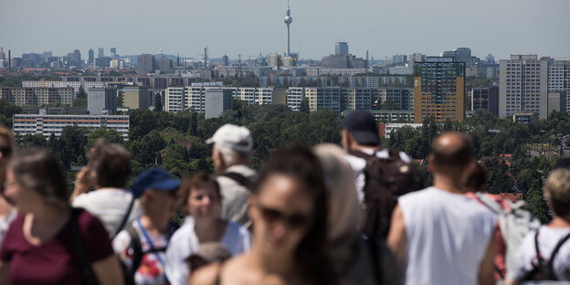 Menschen gucken auf den in der Ferne stehenden Fernsehturm am Alexanderplatz. Menschen gucken auf den in der Ferne stehenden Fernsehturm am Alexanderplatz.