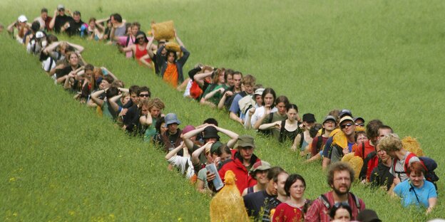 Eine Menschenkette in einem grünen Feld Eine Menschenkette in einem grünen Feld