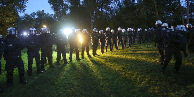 Polizisten stehen auf einer Wiese in der Reihe Polizisten stehen auf einer Wiese in der Reihe