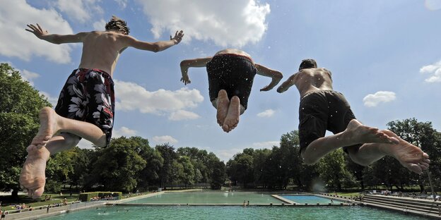 Drei Jungen springen in ein Schwimmbecken Drei Jungen springen in ein Schwimmbecken