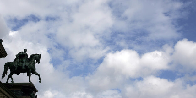 Vor weißen Wolken und einem blauen Himmel ragt eine Reiterstatue Wilhelms des IV. ins Bild Vor weißen Wolken und einem blauen Himmel ragt eine Reiterstatue Wilhelms des IV. ins Bild