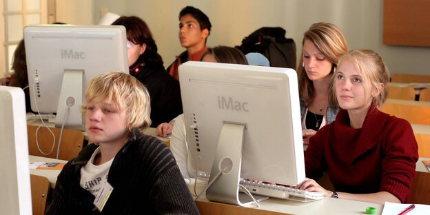 Schüler und Schülerinnen sitzen vor einem Computer Schüler und Schülerinnen sitzen vor einem Computer