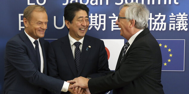 Donald Tusk, Shinzo Abe und Jean-Claude Juncker legen lächelnd ihre Hände übereinander Donald Tusk, Shinzo Abe und Jean-Claude Juncker legen lächelnd ihre Hände übereinander
