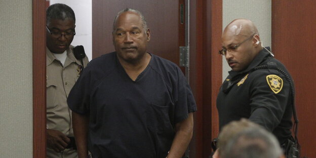 O.J. Simpson läuft in einen Gerichtssaal, neben ihm ein Polizist O.J. Simpson läuft in einen Gerichtssaal, neben ihm ein Polizist