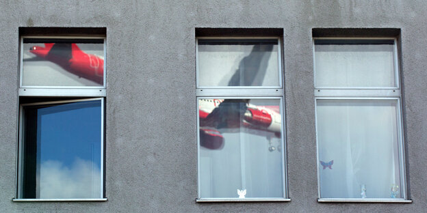 Ein Flugzeug spiegelt sich in einem Fenster Ein Flugzeug spiegelt sich in einem Fenster