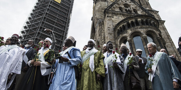 Mehrere Männer stehen vor der Gedächtniskirche Mehrere Männer stehen vor der Gedächtniskirche