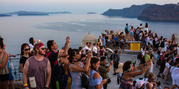 Viele Touristen am Meer, sie machen Fotos und gucken in die Ferne Viele Touristen am Meer, sie machen Fotos und gucken in die Ferne
