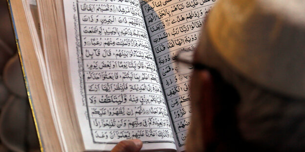 Ein Mann liest im arabischsprachigen Koran Ein Mann liest im arabischsprachigen Koran
