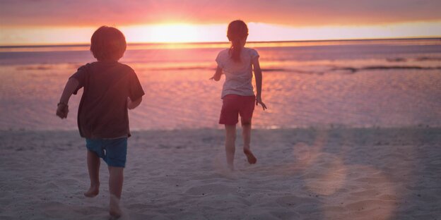 Zwei Kinder laufen Richtung Sonnenuntergang Zwei Kinder laufen Richtung Sonnenuntergang
