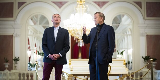 Zwei Männer stehen in einem prunkvollen Theater Zwei Männer stehen in einem prunkvollen Theater