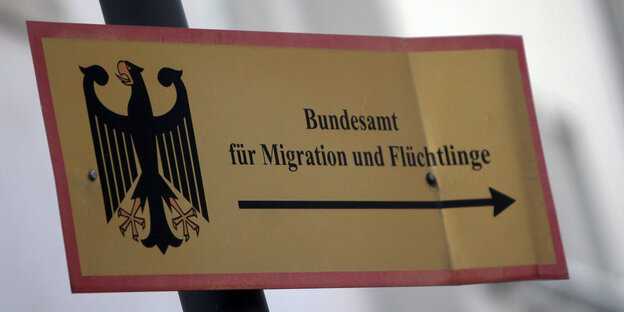 Ein Zettel mit einem Pfeil und der Aufschrift "Bundesamt für Migration und Flüchtlinge" Ein Zettel mit einem Pfeil und der Aufschrift "Bundesamt für Migration und Flüchtlinge"