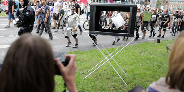 Eine Person fotografiert durch einen alten Fernseher eine Anti-G20-Demo Eine Person fotografiert durch einen alten Fernseher eine Anti-G20-Demo