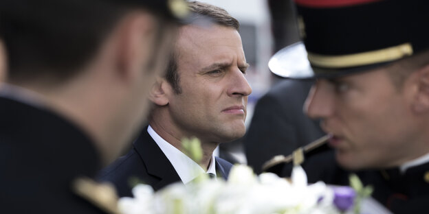 Emmanuel Macron im Hintergrund zwischen zwei Soldaten Emmanuel Macron im Hintergrund zwischen zwei Soldaten