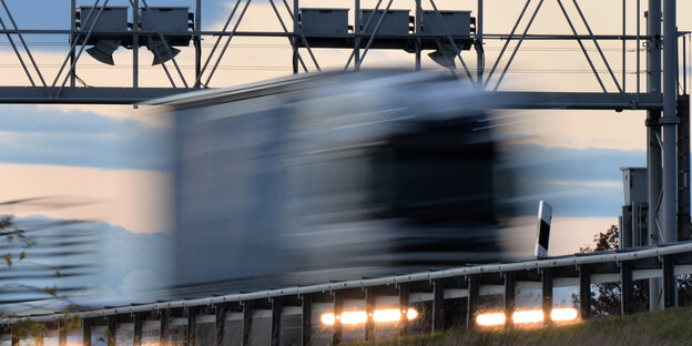 Ein Lkw rauscht an einer Mauterkontrollbrücke vorbei Ein Lkw rauscht an einer Mauterkontrollbrücke vorbei