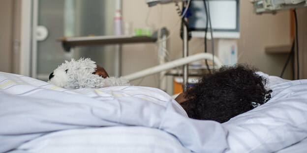 Eine Frau liegt in einem Krankenhausbett Eine Frau liegt in einem Krankenhausbett