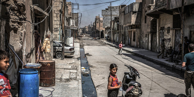 Kinder auf einer Straße, alle Gebäude sind zerstört