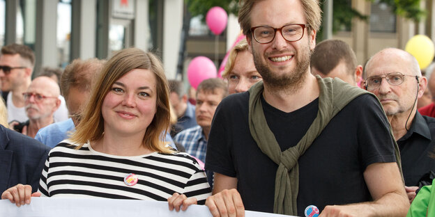 Zwei Menschen halten ein Transparent