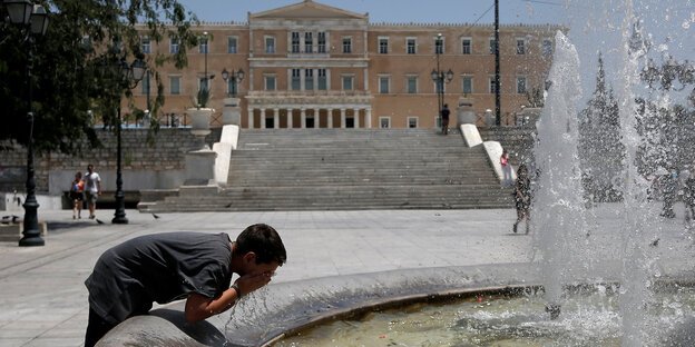 Ein Mann erfrischt sich an einem Brunnen in Athen Ein Mann erfrischt sich an einem Brunnen in Athen