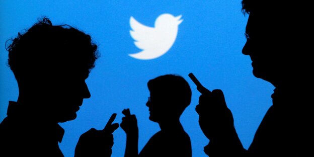 Die Silhouette von drei Menschen vor einem blauen Hintergrund mit einem weißen Vogel-Logo Die Silhouette von drei Menschen vor einem blauen Hintergrund mit einem weißen Vogel-Logo