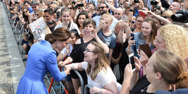 Kate Middleton steht vor ihren Fans am Brandenburger Tor, nur ein Metallzaun trennt sie von einander. Kate Middleton steht vor ihren Fans am Brandenburger Tor, nur ein Metallzaun trennt sie von einander.