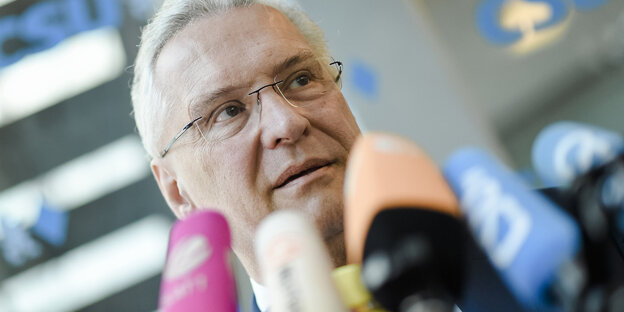 Das Gesicht eines Mannes vor Mikrofonen Das Gesicht eines Mannes vor Mikrofonen