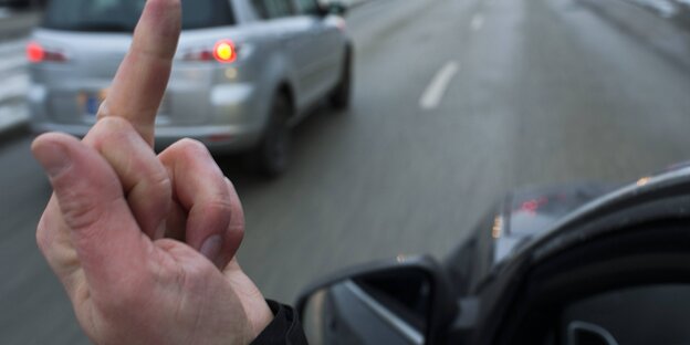 Autofahrer zeigt Mittelfinger Autofahrer zeigt Mittelfinger