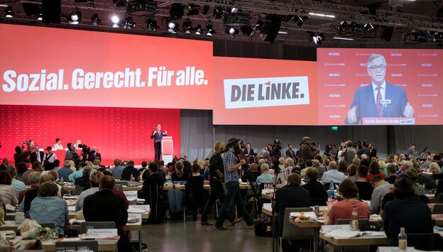 Viele Leute in einer Halle, im Hintergrund ein Schild: "soial. gerecht. für alle. die linke" Viele Leute in einer Halle, im Hintergrund ein Schild: "soial. gerecht. für alle. die linke"