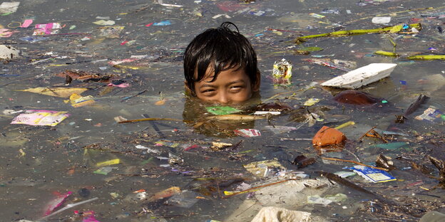 Junge in verdrecktem Wasser