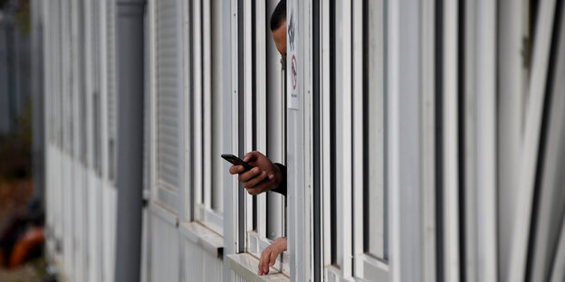 Ein Mann am Fenster mit Mobiltelefon Ein Mann am Fenster mit Mobiltelefon