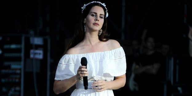 Eine Frau im weißen Kleid mit weißen Blumen im Haar Eine Frau im weißen Kleid mit weißen Blumen im Haar