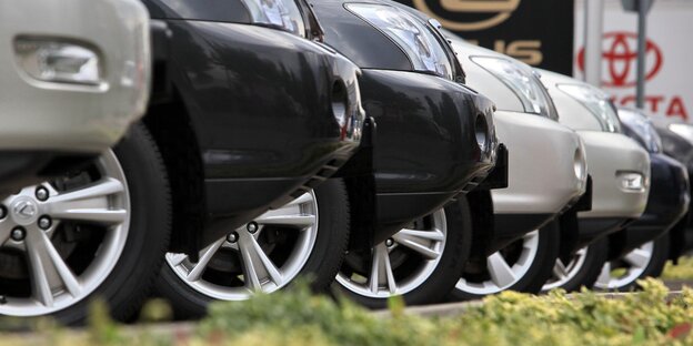 Schwarze und silberfarbene Autos stehen säuberlich nebeneinander geparkt ein einer Reihe, zu sehen sind nur die Spitzen der Motorhauben Schwarze und silberfarbene Autos stehen säuberlich nebeneinander geparkt ein einer Reihe, zu sehen sind nur die Spitzen der Motorhauben