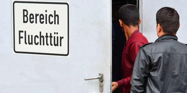 Menschen vor einer Fluchttür Menschen vor einer Fluchttür