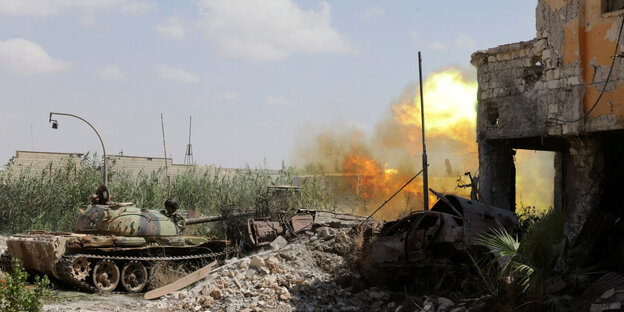 Ein Panzer vor einer Explosion und einem kaputten Gebäude Ein Panzer vor einer Explosion und einem kaputten Gebäude